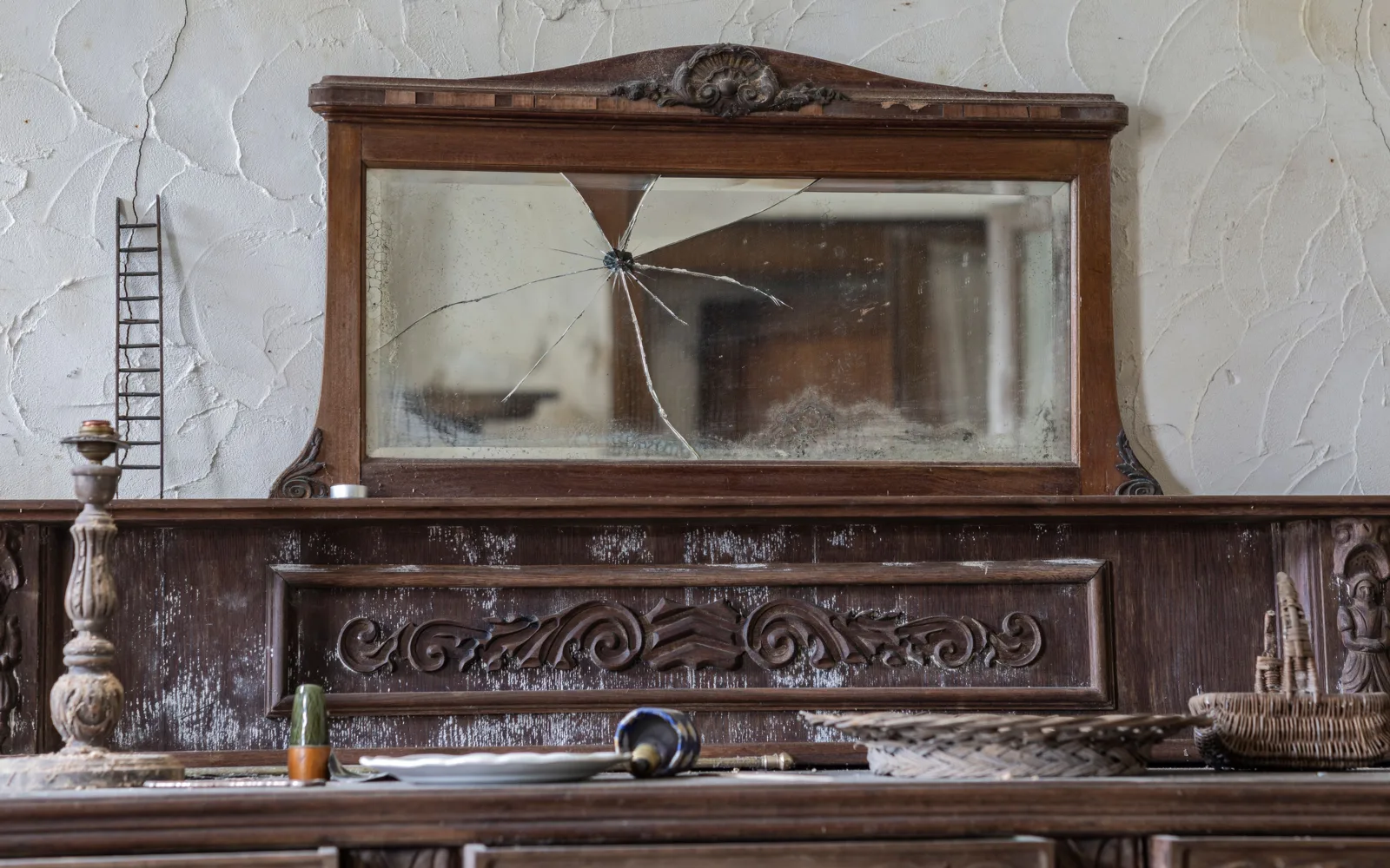 Buffet ancien en bois sculpté, patiné, surmonté d’un miroir fendu